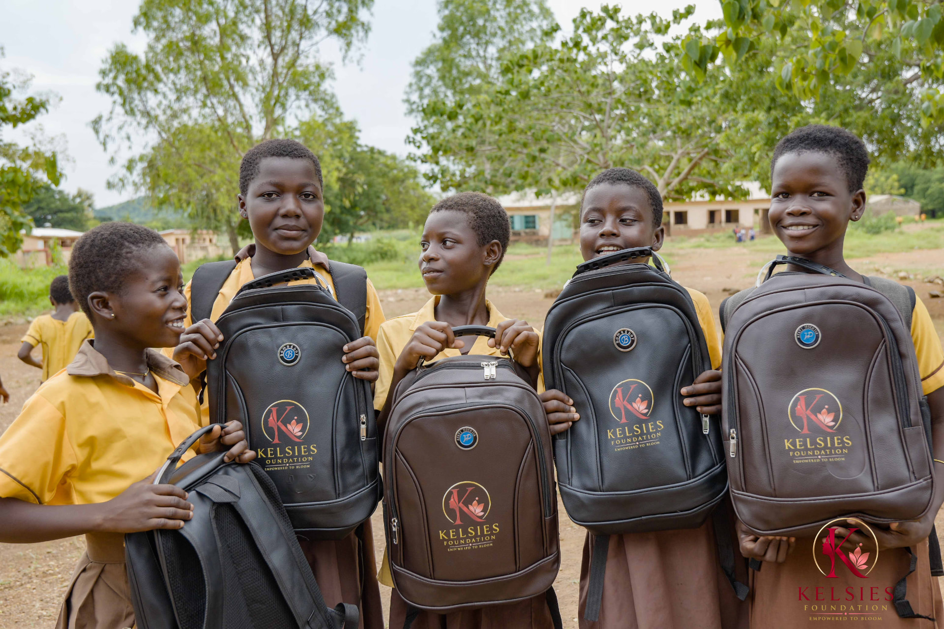 Five schoolgirls proudly holding their new Kelsies Foundation backpacks