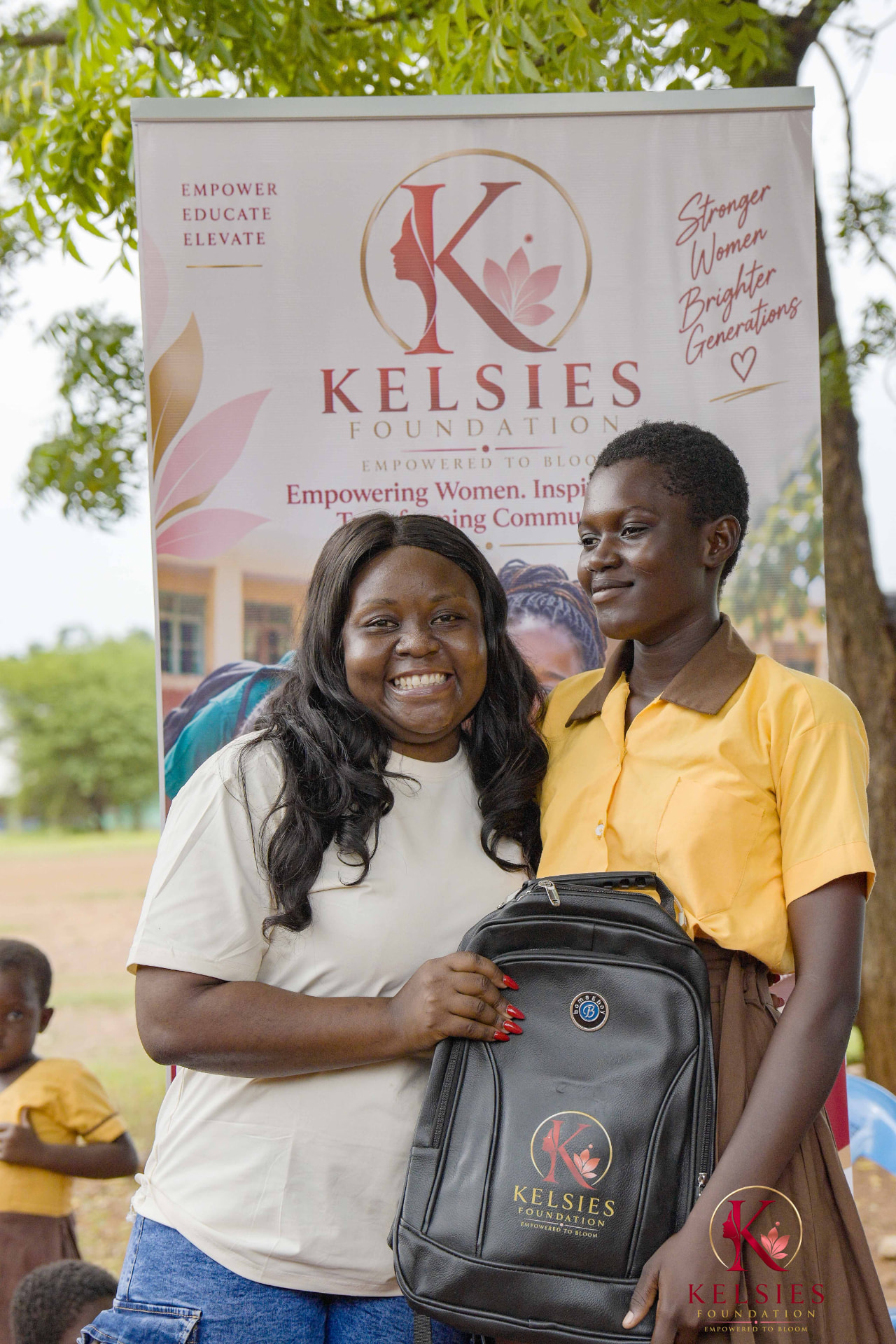 A Kelsies Foundation representative with a student and her new backpack