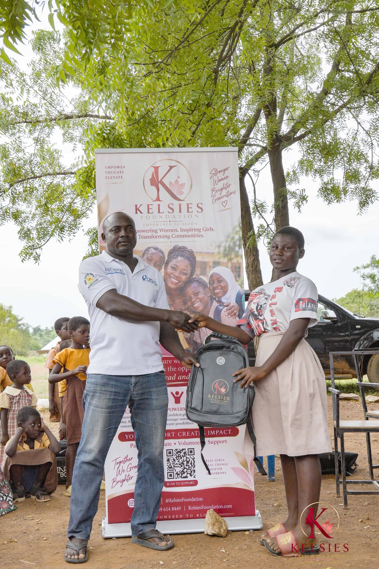 A school representative presenting a Kelsies Foundation backpack to a student